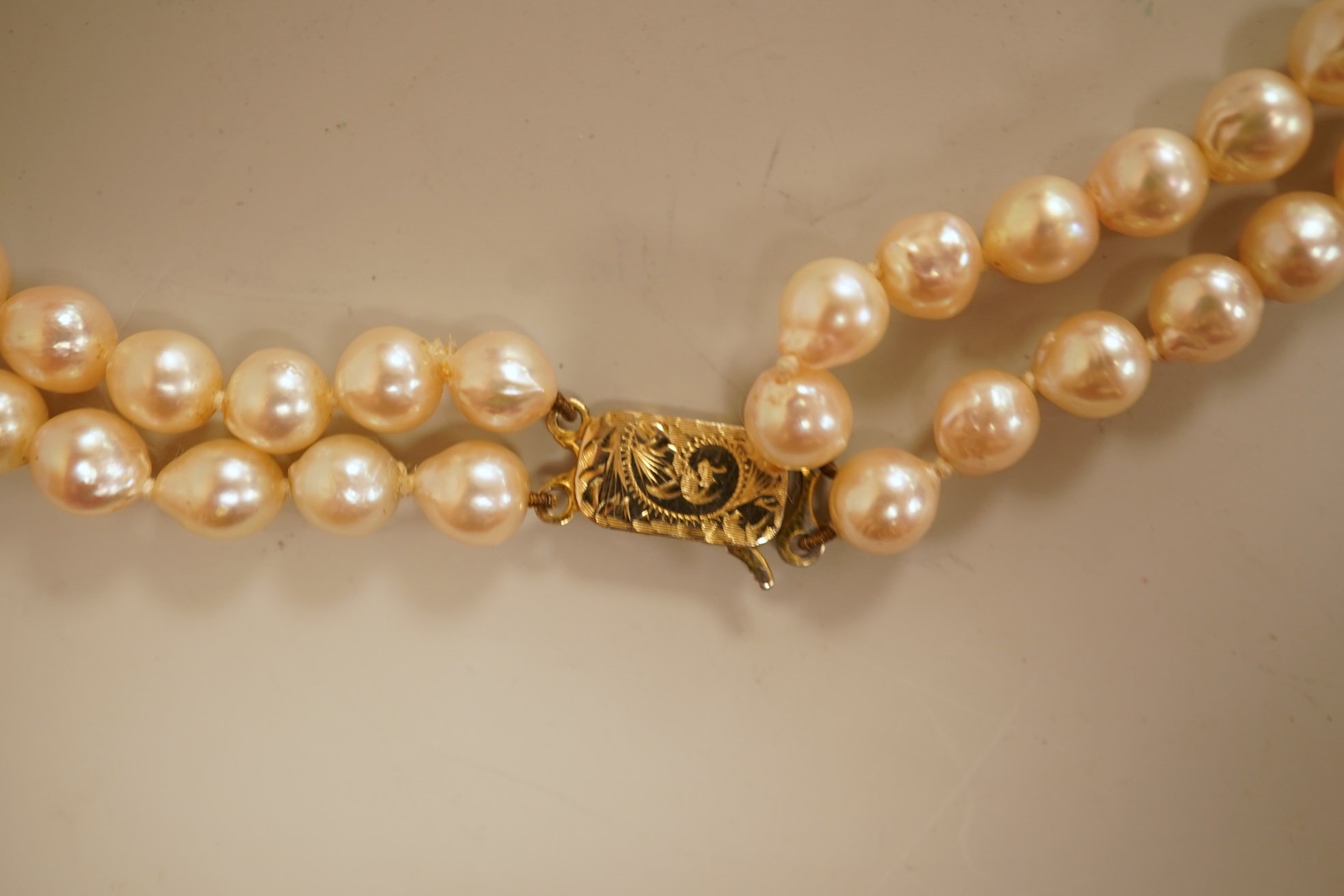 A modern twin strand cultured pearl choker necklace, with an engraved 9ct clasp, approx. 40cm, together with a cultured pearl bracelet, with diamond chip set butterfly shaped 14k clasp, 18cm, with four fluted yellow meta